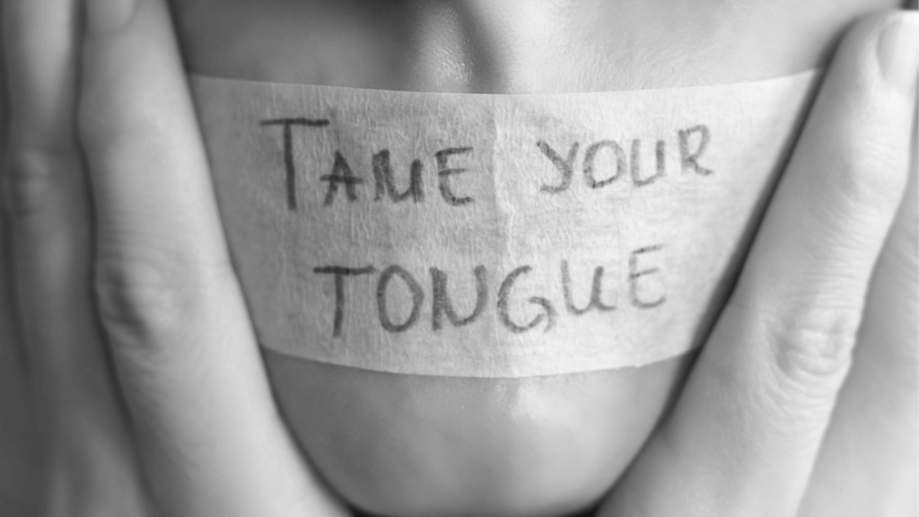 Tape covering a mans mouth that reads "Tame your tongue"