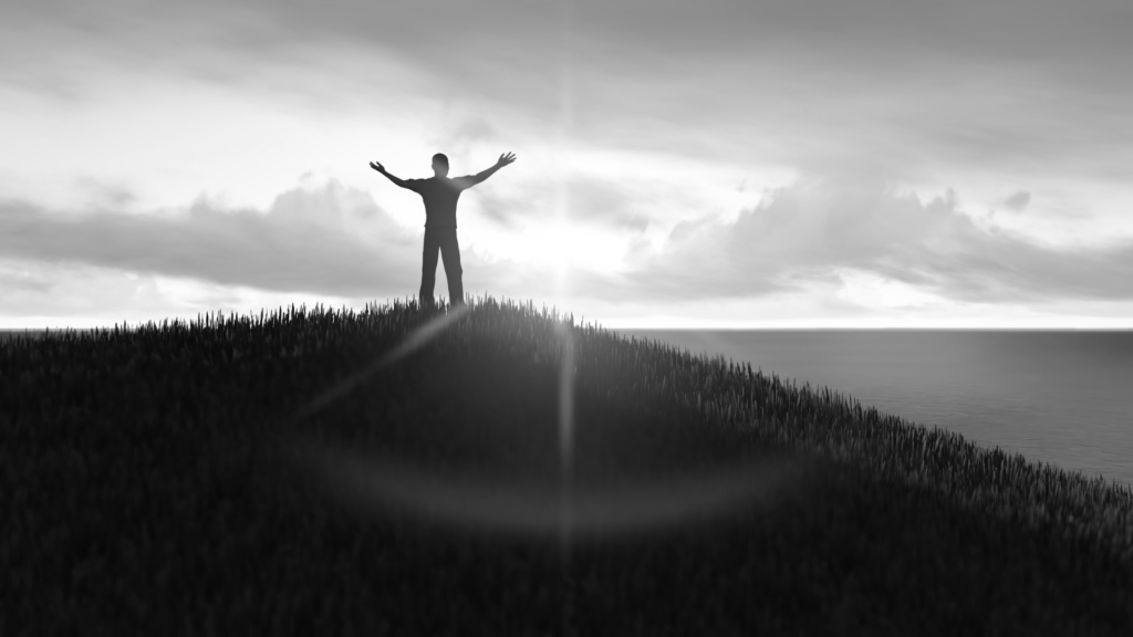 Man on a mountain top in surrender to God.